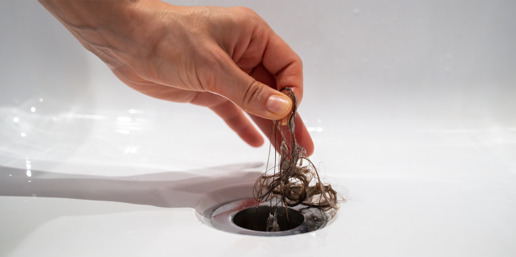 Bathroom drain clogged with hair and soap buildup