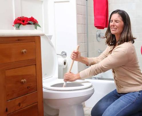 plumber inspecting toilet drain for clog removal in Pueblo Colorado